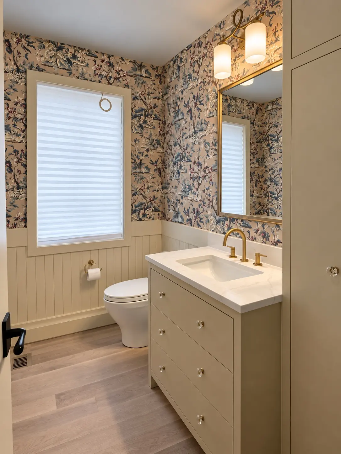 Completed bathroom with white vanity, patterned wall finish, and brass lighting