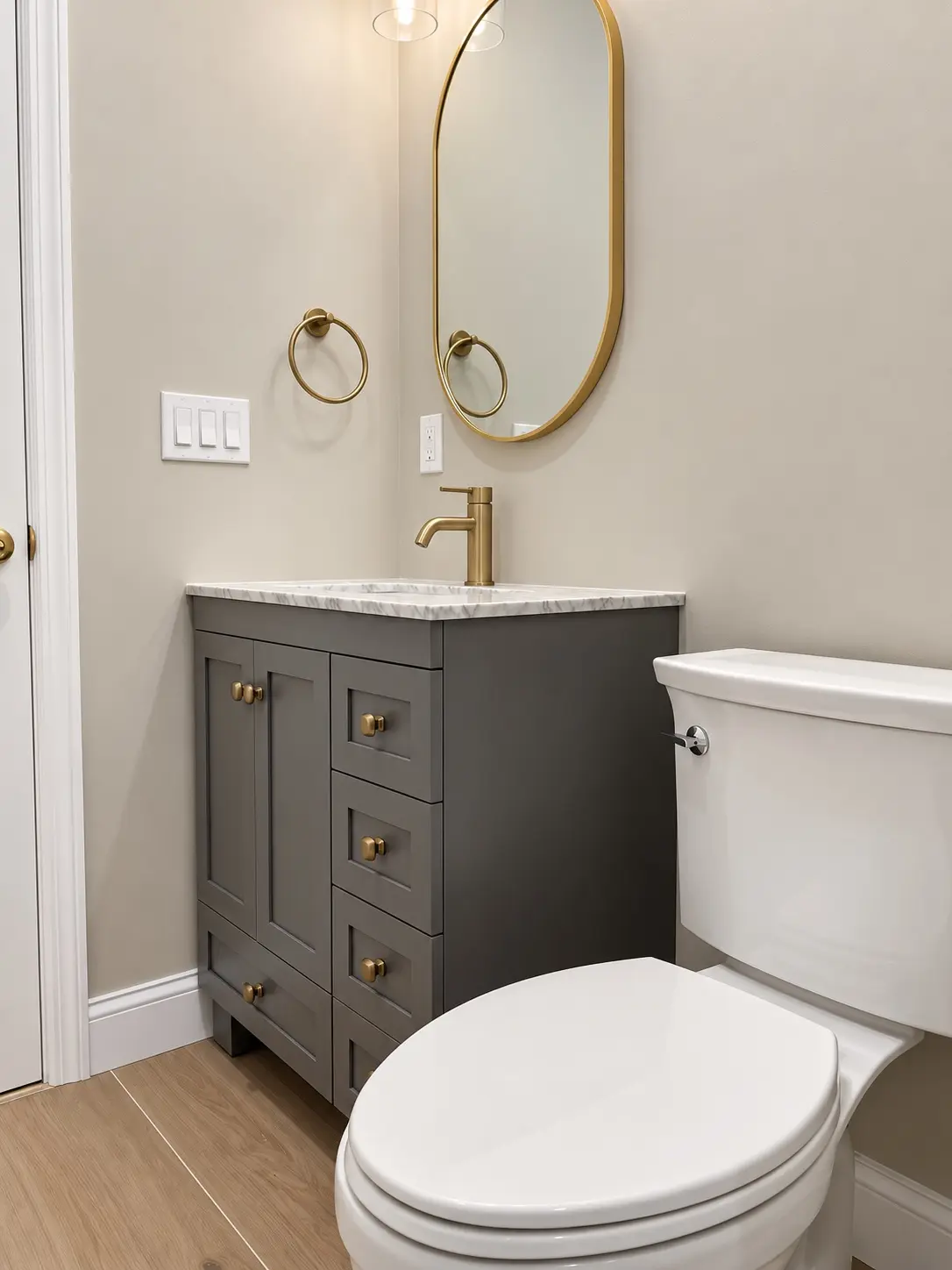 Finished powder room with custom vanity, stone top, and brass fixtures