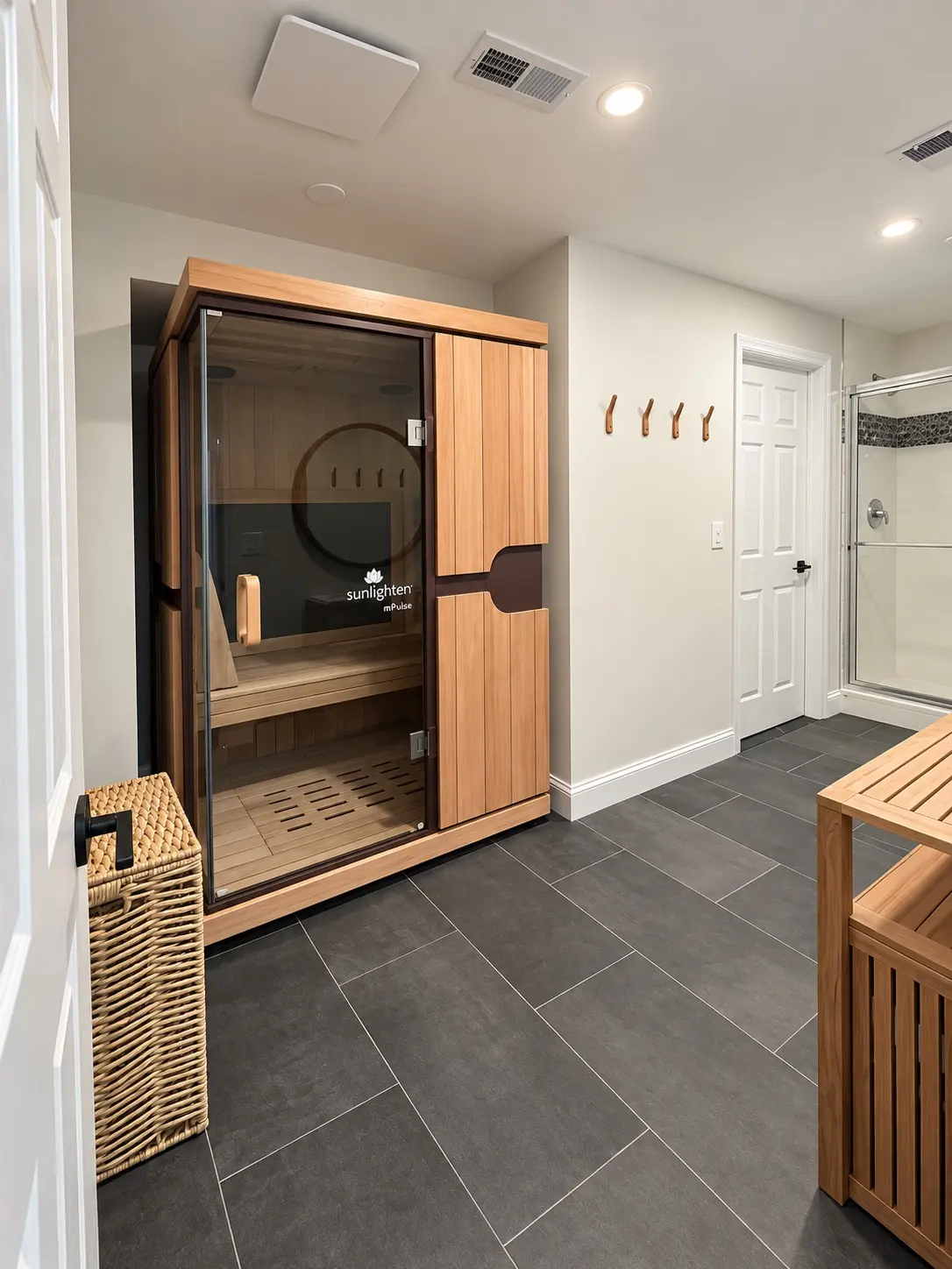 Sauna room with coordinated custom wood cabinetry and tile floor