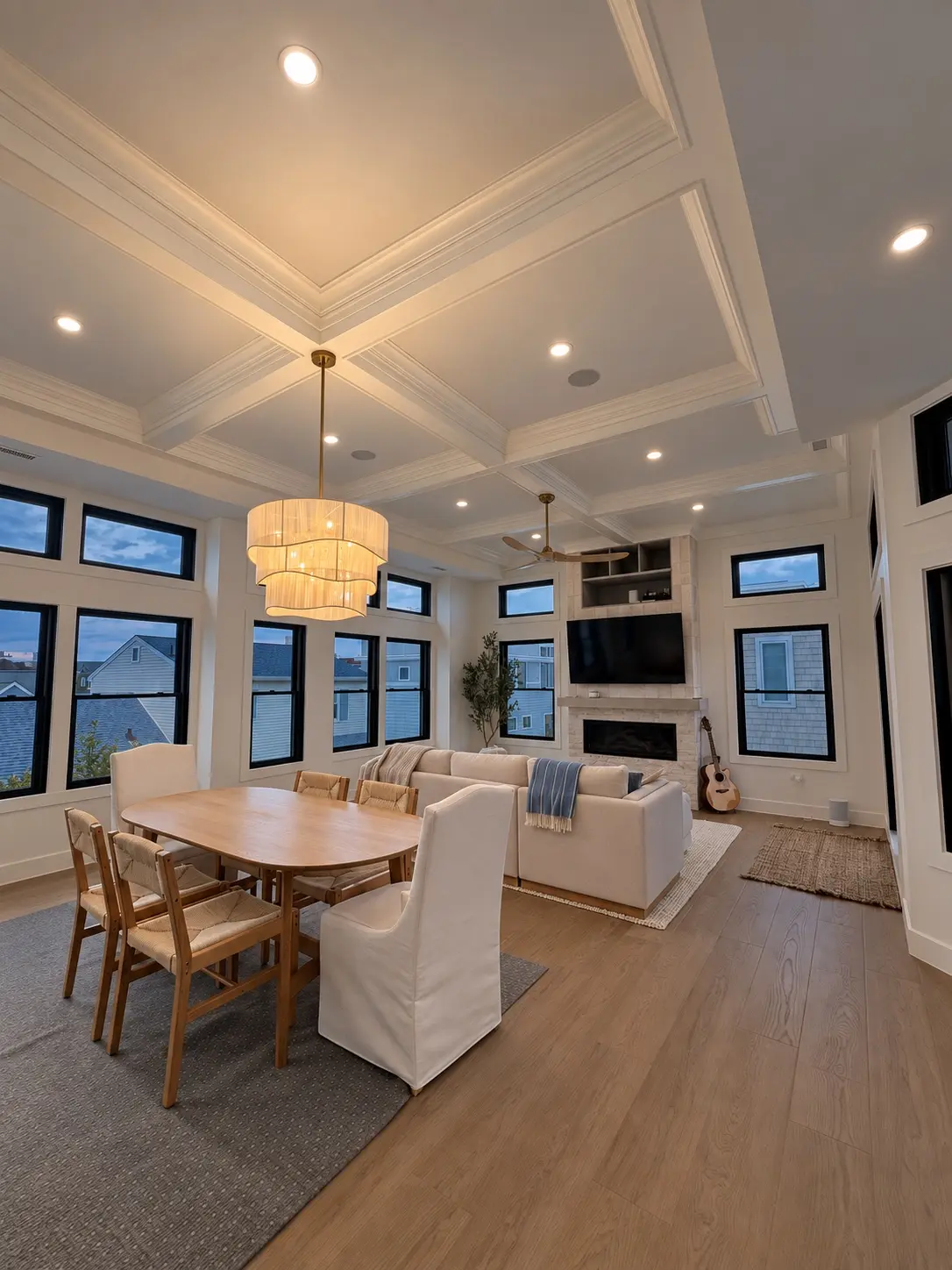 Custom recessed and chandelier lighting in a coffered-ceiling living space