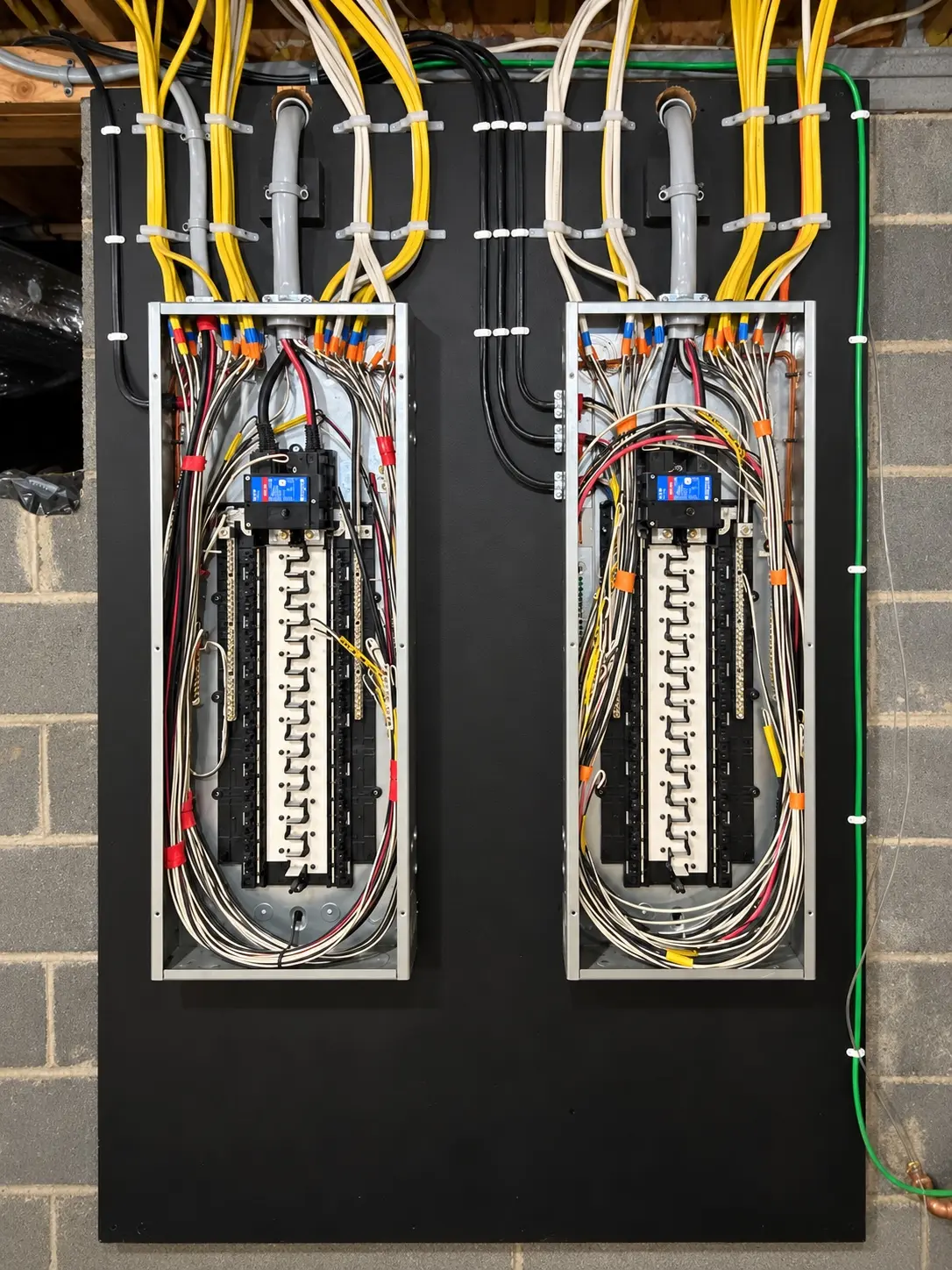 Two neatly organized electrical panels with carefully routed and secured conductors