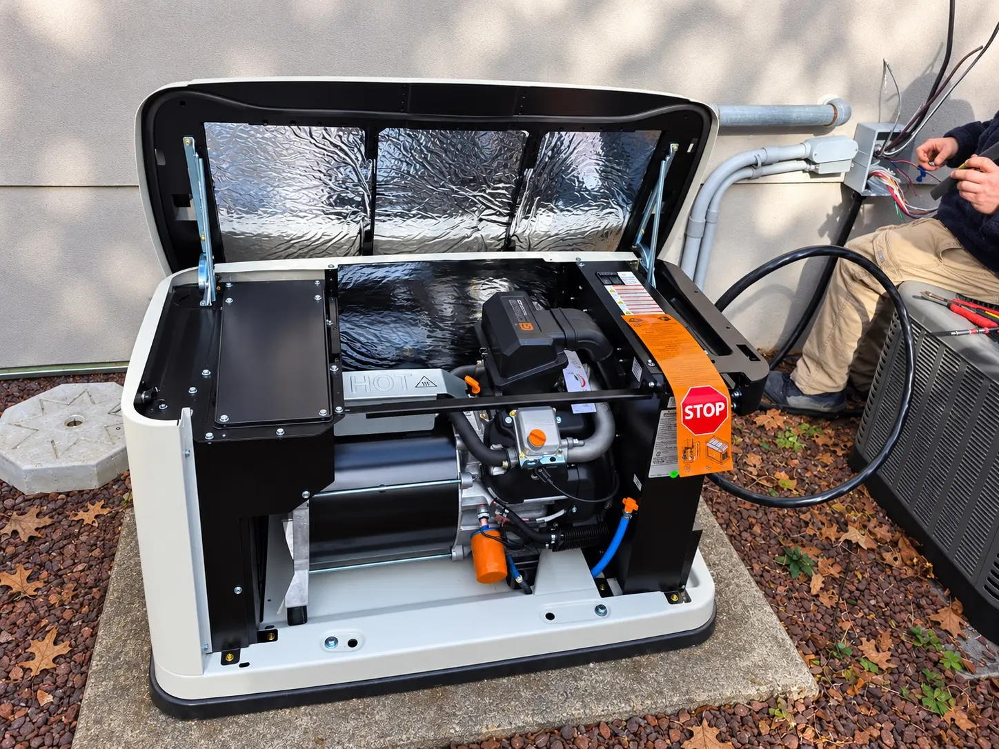 Open Generac standby generator being inspected and serviced by a technician